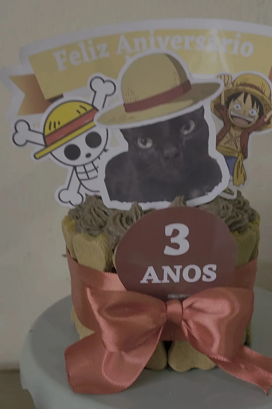 Bolo de aniversário de três anos com laço, montado com biscoitos da casa
