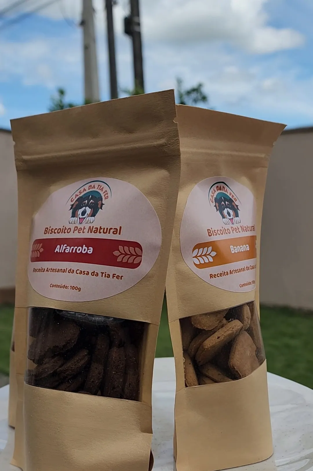 Pacotes de Biscoito Pet Natural nos sabores alfarroba e banana, servidos numa bandeja